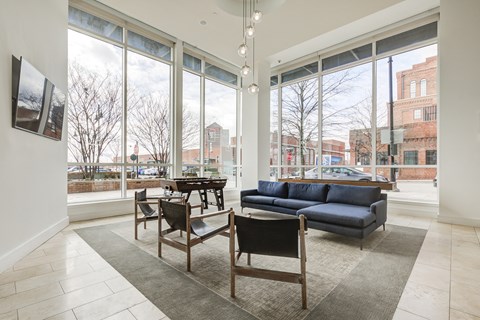 a living room with large windows and a couch and chairs